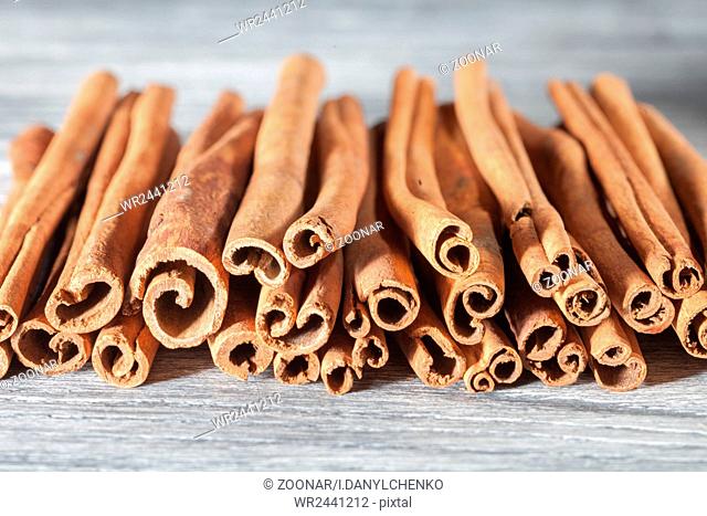 Cinnamon sticks isolated on white wooden table