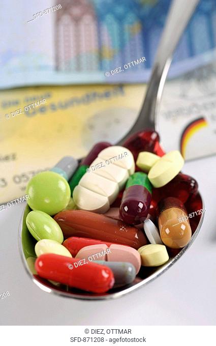 Assorted tablets and capsules on a spoon