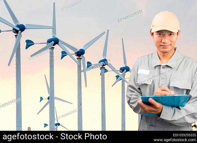 Engineer or technician write book with large Wind Turbine Power Station background