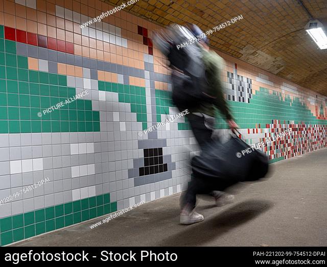02 December 2022, Berlin: A passerby walks through the pedestrian tunnel newly designed by illustrator Christoph Niemann at Wannsee station