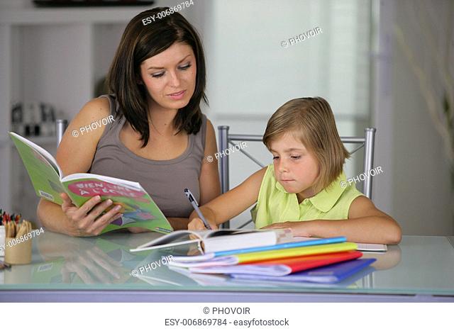 Mother helping daughter with schoolwork