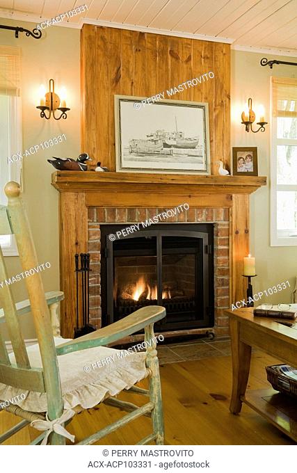 Gas fireplace in the living room of an Old Canadiana cottage style (circa 1866) Residential home, Quebec, Canada. This image has a limited use property release
