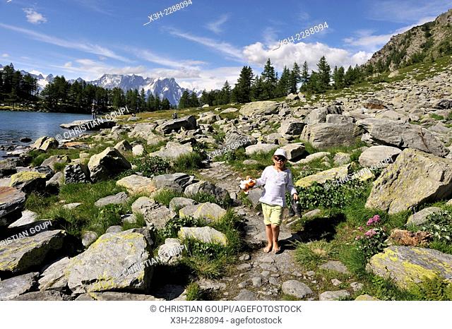 little girl walking on the bank of the mountain lake Arpy, near La Thuile, Aosta Valley, Italy, Europe