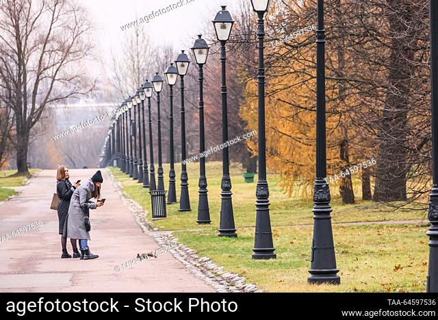 RUSSIA, MOSCOW - NOVEMBER 9, 2023: Girls looks at a squirrel in Tsaritsyno Park in autumn. Mikhail Metzel/TASS