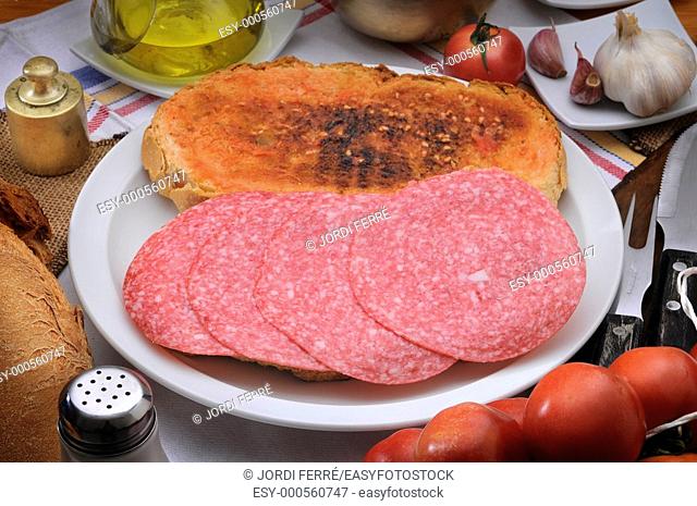 Toasted bread with tomatoes and sliced salami, Pan tostado con tomate y salami en rodajas