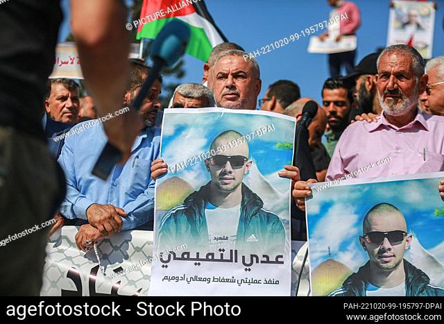 20 October 2022, Palestinian Territories, Gaza City: Palestinians take part in a mourning vigil at the Unknown Soldier's Square while carrying pictures of Uday...