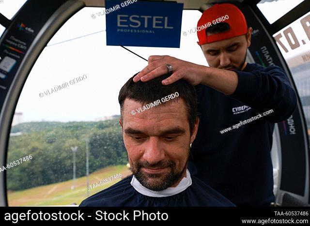 RUSSIA, MOSCOW - JULY 19, 2023: A man has his hair cut as the Superman barbershop chain attempts to set a world record for the most haircuts given in a moving...