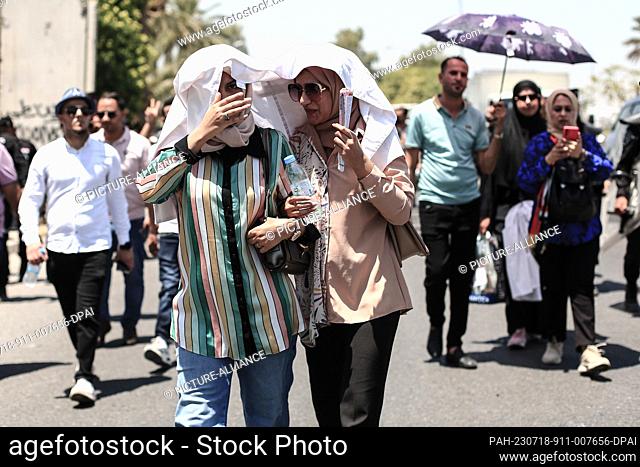 18 July 2023, Iraq, Baghdad: Protesters cover their heads with a scarf during a protest near the Turkish Embassy in Baghdad