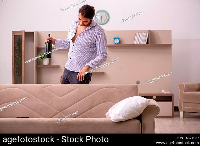Young drunken man suffering at home