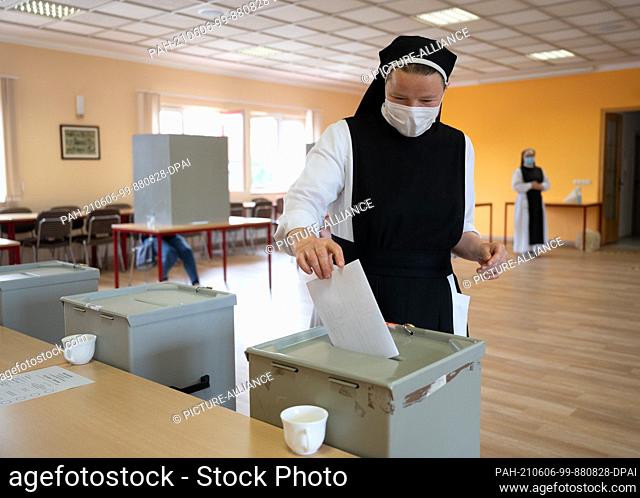 06 June 2021, Saxony-Anhalt, Eisleben: Sister Gertrud from the Cistercian convent of Helfta throws her ballot paper into the ballot box at the polling station...