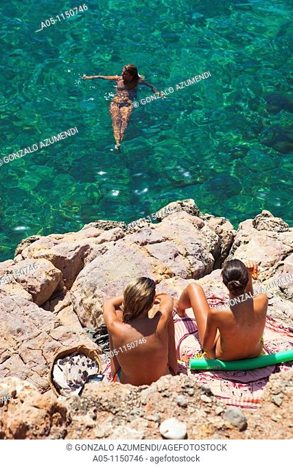 Young people on the beach. Cala Salada beach. Santa Agnés de Corona. Ibiza. Balearic Islands. Spain