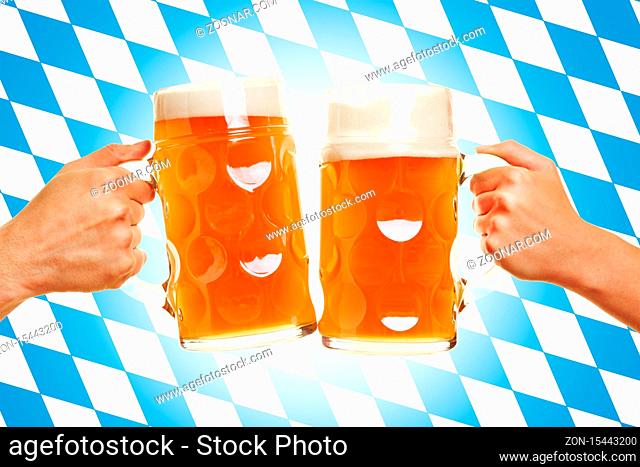 Zwei Hände stoßen mit Bier in Biergläsern an vor einer bayrischen Flagge