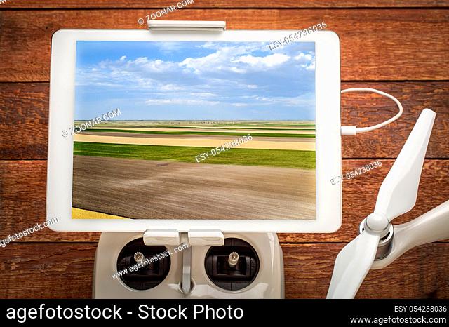 rural Nebraska landscape with wheat, corn and plowed fields - reviewing an aerial image on a digital tablet mounted on a drone radio controller