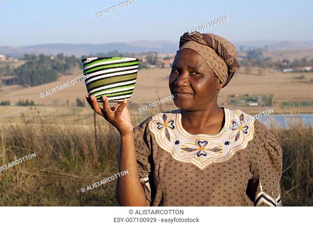 Traditional South African Zulu woman basket sales woman selling colourful ethnic baskets made from recycled wire