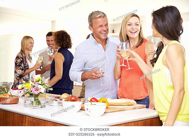 Mature Guests Being Welcomed At Dinner Party By Friends