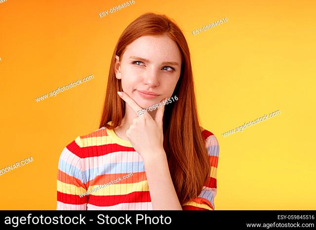 Hmm interesting. Suspicious doubtful attractive european redhead female pondering choice look hesitant thoughtful touch chin smirking tricky look upper left...