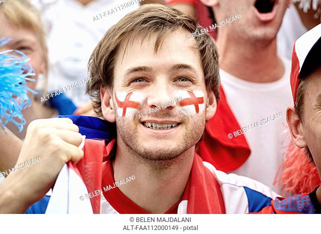 British football fan smiling at match, portrait