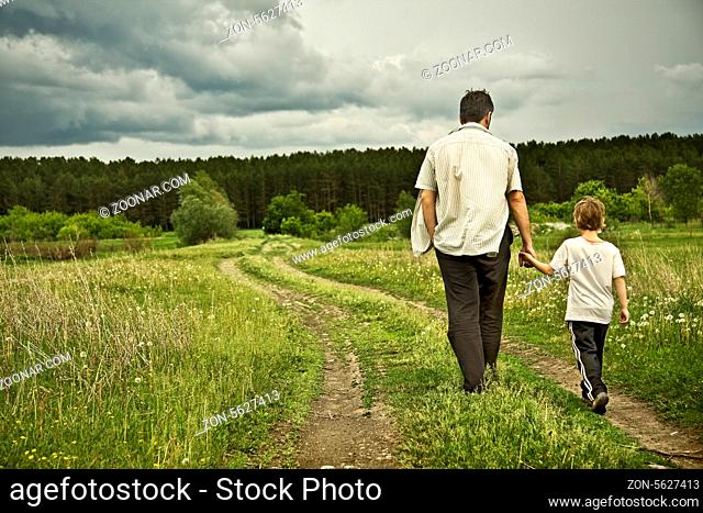 boy and his father are on the road away