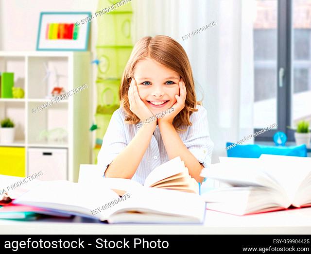 smiling student girl with books learning at home