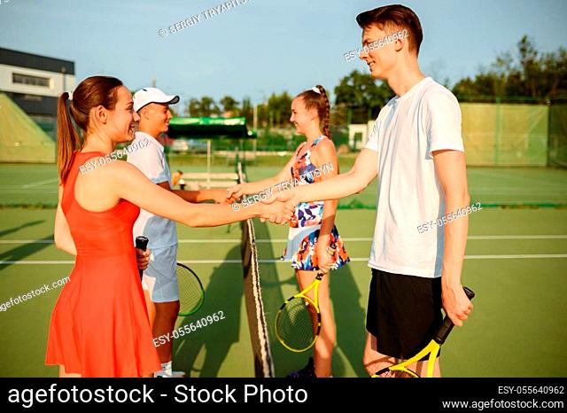 Mixed doubles tennis tournament, outdoor court. Active healthy lifestyle, people play sport game with racket and ball, fitness workout with racquets