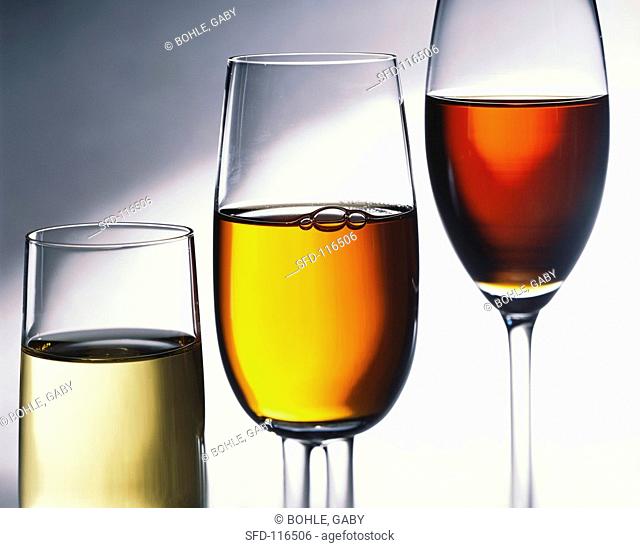 Three glasses of different heights with white, rose & red wine