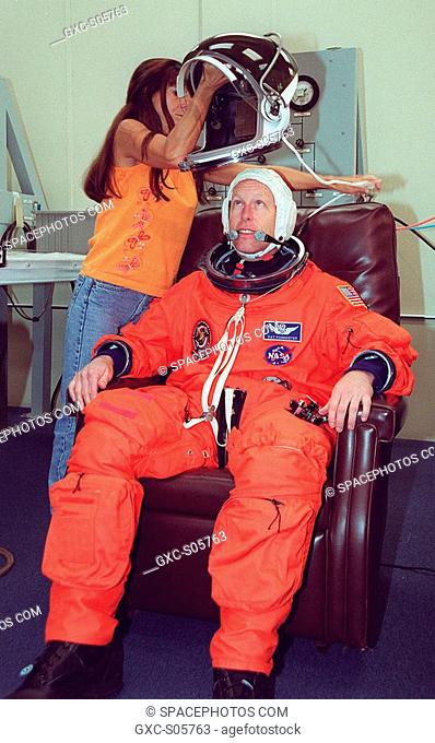 07/18/2001 -- STS-105 Mission Specialist Patrick Forrester waits to don his helmet during suit fit check as part of Terminal Countdown Demonstration Test...