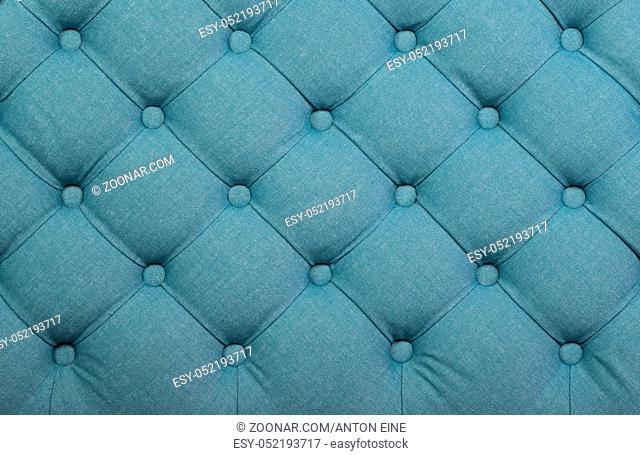 Teal blue capitone textile background, retro Chesterfield style checkered soft tufted fabric furniture decoration with buttons, close up