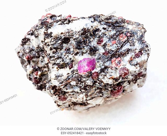 macro shooting of natural mineral rock specimen - raw corundum crystals in gneiss stone on white marble background from Hit-island of Upper Pulongskoye Lake