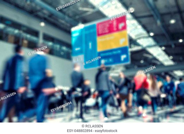 defucsed trade fair background with people walking, ideal background image. ideal for websites and magazines layouts