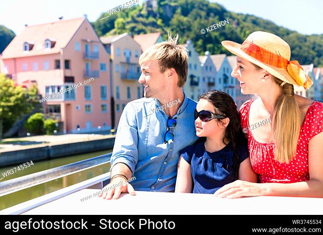 Happy family on river cruise in summer sitting in ship