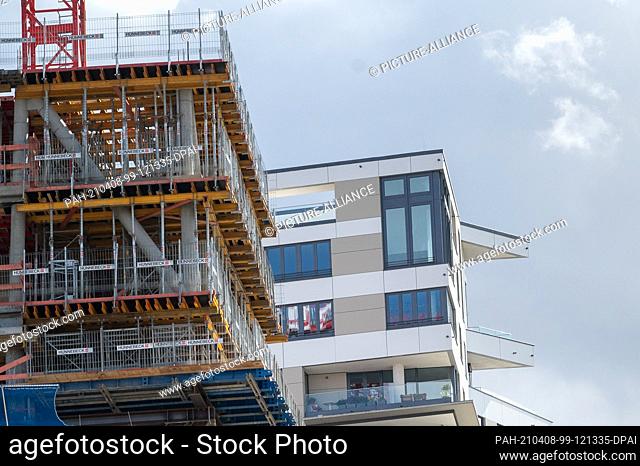 06 April 2021, Hessen, Frankfurt/Main: A building shell stands in front of an already completed new building in the Europaviertel