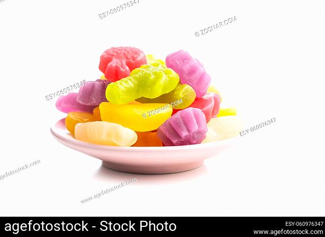 Colorful fruity jelly candies on plate isolated on white background