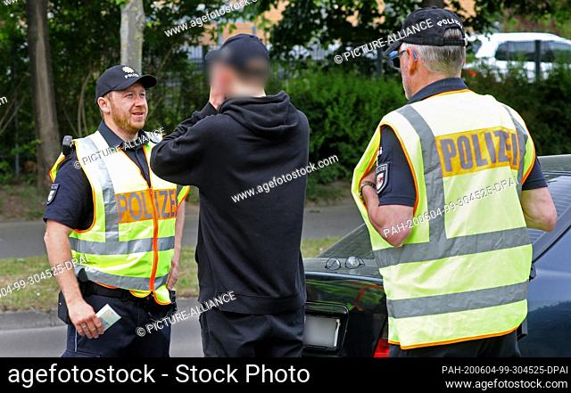 04 June 2020, Mecklenburg-Western Pomerania, Rostock: Two police officers stand next to a car driver after a corona-conditioned break during one of the...