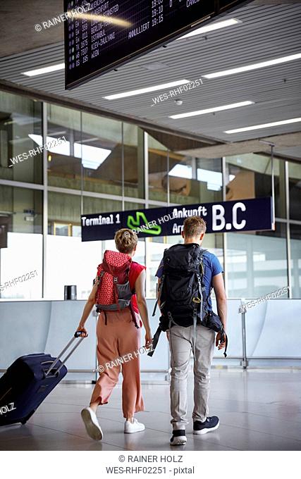 Rear view of couple walking at the airport