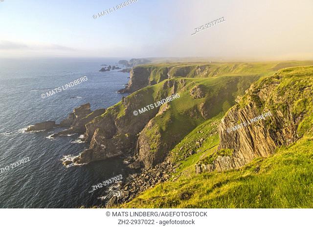 Mull of Oa, Islay, Scotland, in evening time with nice warm light, fog is comming in over the cliffs, gren grass on the ground, Islay, Scotland