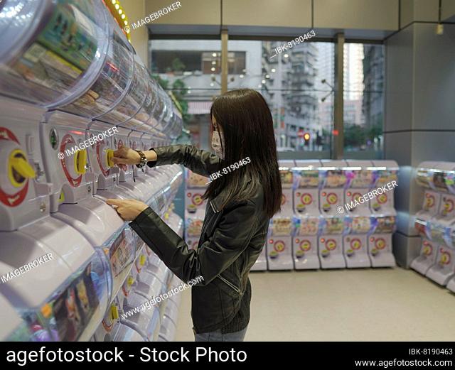 Girl at toy vending machine in Macau, China, Asia
