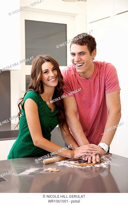 Young couple preparing gingerbread cookies