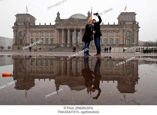Sienna and Dylan from London take a selfie of themselves in front of the Reichstag building, the seat of the German Bundestag, in Berlin, Germany