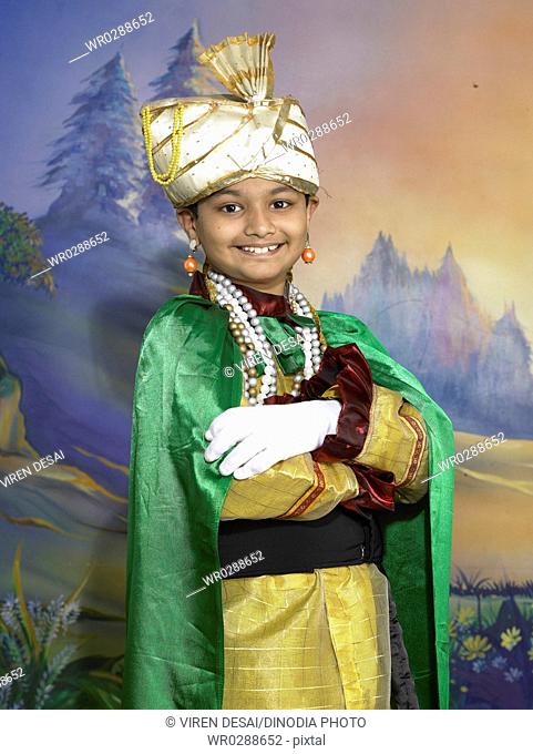 South Asian Indian boy dressed as prince performing fancy dress competition on stage in nursery school MR