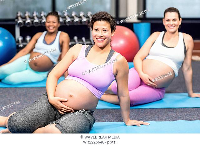 Pregnant woman doing exercise on mat