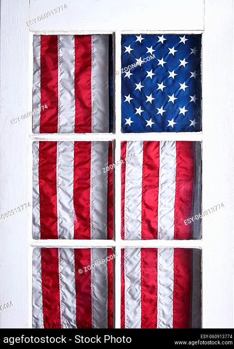 American Flag hanging on the inside of a glass panel door to celebrate the 4th of July