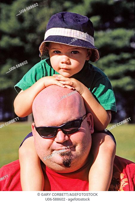 3 yr old boy sitting on fathers shoulders