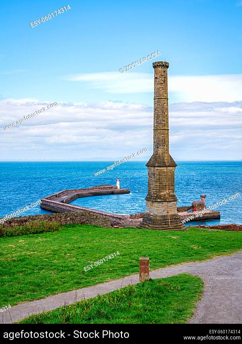 The Candlestick Chimney with the pier and the West Pier Lighthouse in the background, seen in Whitehaven, Cumbria, England, UK