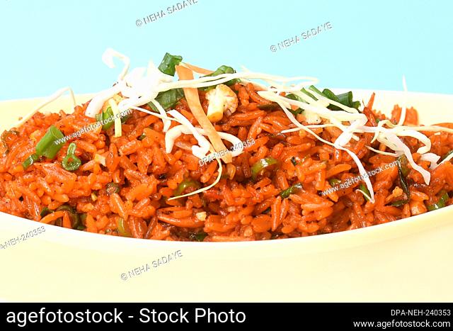 Schezwan fried rice with schezwan sauce, Chinese fried rice, garnished with spring onion and cabbage.indo chinese cuisine dishes.selective focus