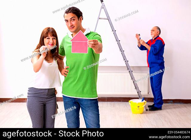 Young couple and old contractor in the home renovation concept