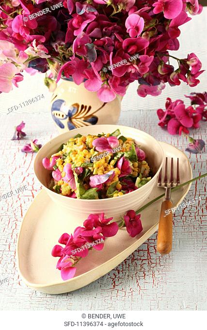 Yellow lentil salad with flowers and wild herbs