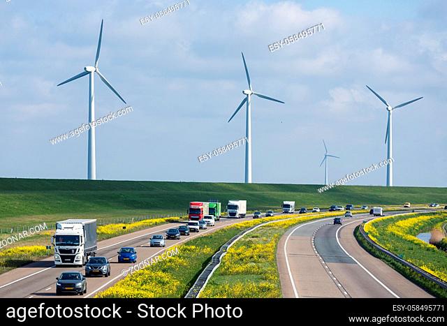 Dutch motorway A6 near Lelystad with wind turbines and blooming rapeseed