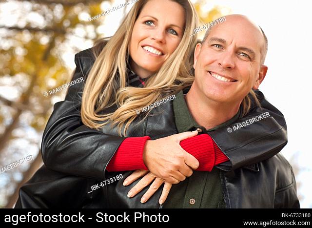 Happy, attractive couple in park with leather jackets