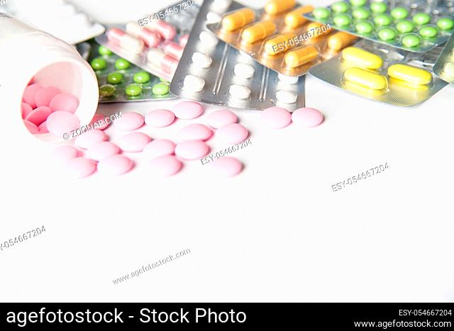Colorful tablets in blisters and bottle on table in close-up