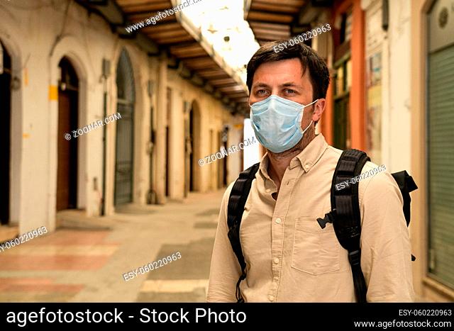 Masked male tourist walks at closed market during coronavirus pandemic, lockdown on Cyprus. Man in mask walks through market in city center